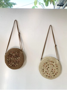 Round handmade straw bags in brown and beige with colorful beaded spiral patterns