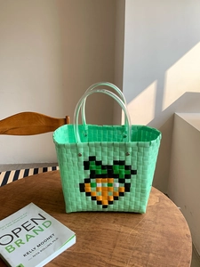 Handmade green woven beach bag with pixel carrot design and clear dual handles