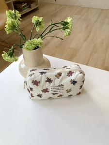 Gros plan détaillé de la trousse de maquillage matelassée avec motifs ours et décor cosy