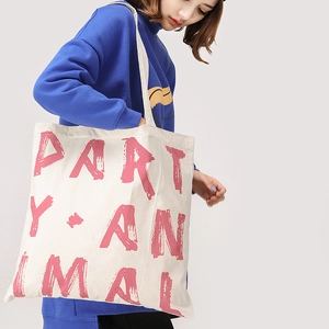 Tragebild der weißen Canvas-Tasche mit Party Animal Aufdruck getragen von einem Model