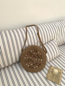 Detail of round straw bag with colorful bead accents and adjustable leather strap