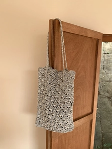 Detail of silver handcrafted crochet bag with metallic thread and scallop pattern