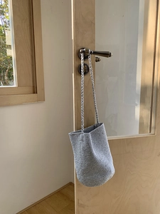 Sac seau tissé argenté avec fil métallique suspendu à une poignée de porte intérieure
