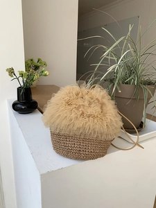 Detail einer handgefertigten Stroh-Beuteltasche mit Tüll-Rüschen und Kordelzug-Träger