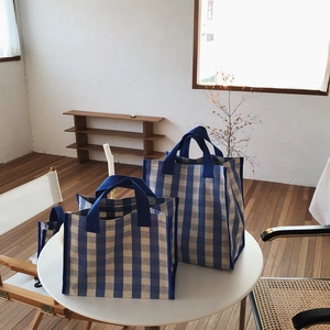 Detailed view of blue and white gingham canvas tote bags in large and small sizes