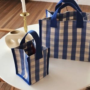 Detailed comparison of large and small blue checkered canvas tote bags with navy handles
