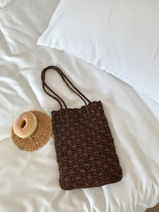 Close-up of brown hand-woven shoulder bag featuring intricate shell crochet patterns