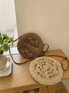 Detailed close-up of handmade round woven straw bags with colorful bead embellishments