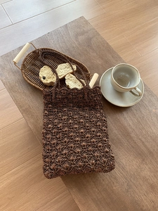 Detailed close-up of brown hand-woven tote bag with textured knit pattern and twin handles