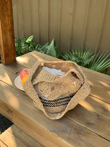 Détail du motif floral ajouré au crochet sur ce sac cabas en paille pour l'été