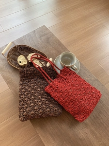 Detail of handmade crochet shoulder bags with intricate hollow fan pattern and slim straps