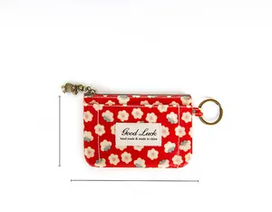 Détail du porte-monnaie en tissu à fleurs rouges avec zip en laiton et taille 12x9cm