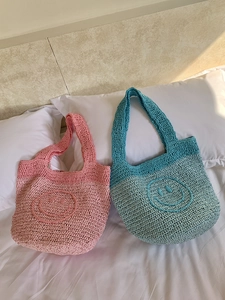 Handmade bohemian knit mini tote bag with smiling face pattern in pink and teal colors