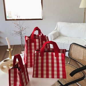 Three-piece red and white checkered canvas tote bag set on a minimalist white table