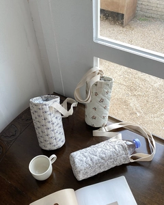 Quilted fabric water bottle carriers with floral patterns and adjustable straps
