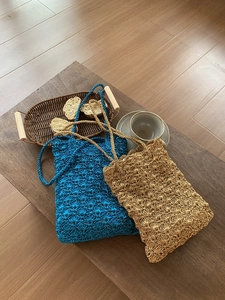 Detailed handmade crochet bag with blue scallop pattern on a natural wooden table