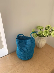 Sac seau bleu tissé à la main avec finition métallisée sur table en bois