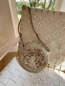 Detail of round straw bag with colorful beads and adjustable leather shoulder strap