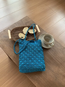 Detailed close-up of a royal blue hand-woven crochet tote bag with textured shell patterns