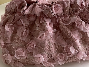 Detail of pink lace handbag with 3D organza roses and intricate floral embroidery
