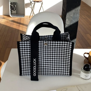 Détail du sac cabas pied-de-poule noir et blanc avec une sangle logo Goodluck verticale