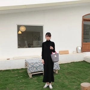 Look extérieur avec sac matelassé gris à anses roses et robe mi-longue noire élégante