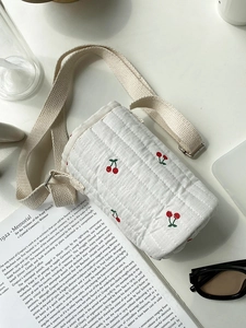 Detail of white quilted cherry print water bottle carrier bag with adjustable strap