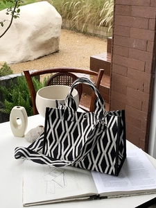 Sac fourre-tout en toile à motifs de losanges avec bandoulière sur table