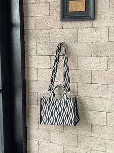 Détail d'un sac cabas à motifs géométriques noir et blanc avec bandoulière large