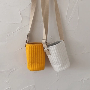 Detailed view of quilted water bottle bags in yellow and white with adjustable straps