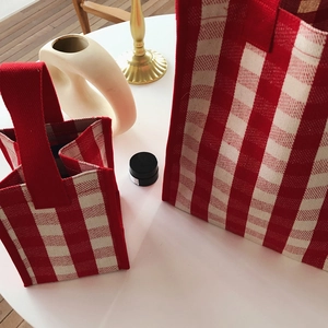 Detail of red and white checkered canvas tote bag set with textured woven fabric