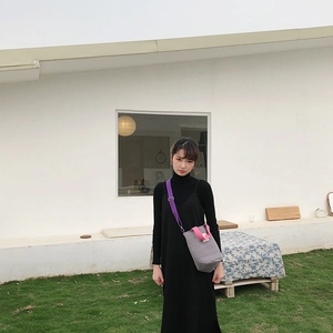 Sac seau en toile matelassée grise avec anses roses et bandoulière violette en extérieur