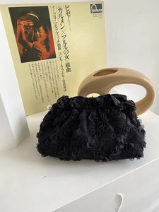 Detail of 3D rose petal texture on black party clutch bag with pearl clasp