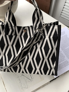 Gros plan du motif géométrique noir et blanc sur la texture du sac cabas en toile