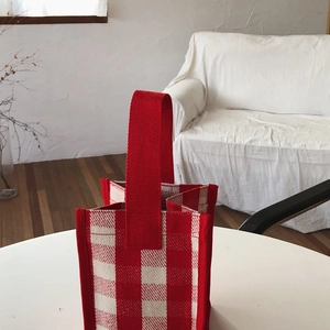 Close-up of durable red and white checkered canvas tote bag with thick woven texture