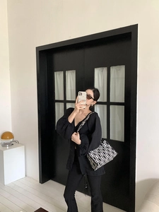 Sac fourre-tout chic à motif ondulé noir et blanc présenté dans un cadre de vie élégant