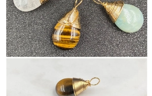 Detalle macro de colgantes de gota envueltos en alambre con ojo de tigre y cristal