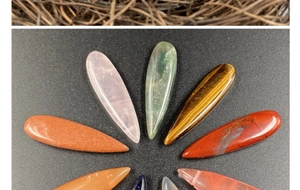 Polished teardrop semi-precious stones including rose quartz and agate in radial layout