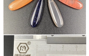 Size reference for colorful resin teardrop beads with a steel ruler on black background