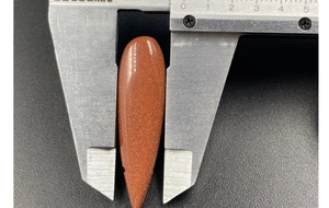 Detailed measurement of a 10mm teardrop goldstone pendant with a digital caliper