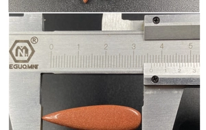 Macro shot of a 28.5mm goldstone teardrop pendant measured with a caliper
