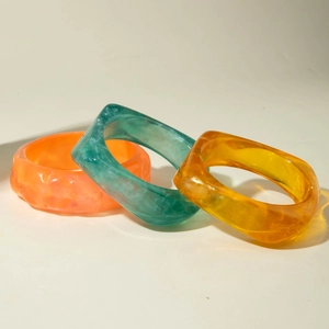 Three-piece gradient translucent resin bangle set in orange, dark green, and amber yellow