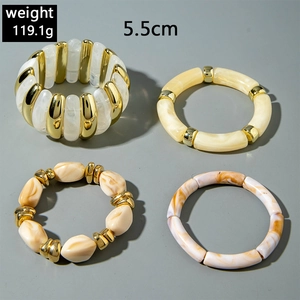 Detail of 4-piece chunky resin bead bracelets with marble texture and gold accents