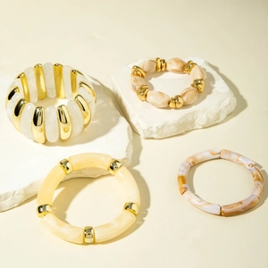 Detailed close-up of acrylic beaded bracelets with marble textures on stone props