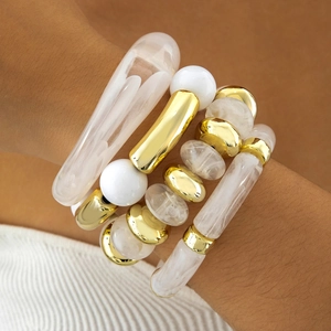 Irregular acrylic bead bracelet set with gold accents on a model wrist