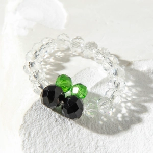 Macro view of a handmade beaded flower ring with colorful faceted transparent beads