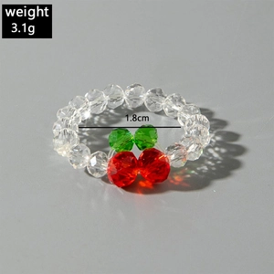 Macro detail of cherry beaded ring showing red fruit beads and green leaf beads