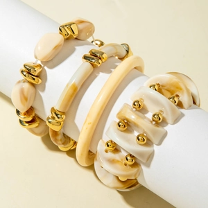 Detail of four-piece cream acrylic beaded bracelet set with gold irregular metal accents