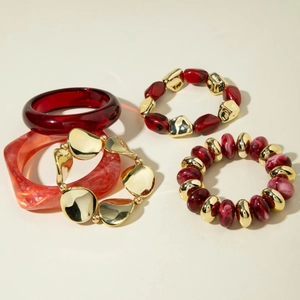 Set of 5 bohemian bracelets featuring red marble resin bangles and gold beaded stretch links