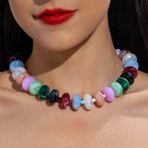 Macro detail of colorful acrylic beaded necklace with marble texture on model
